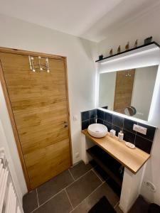a bathroom with a wooden door and a sink at Seven Keys - La cour du Barres in Saint-Vincent-de-Barrès