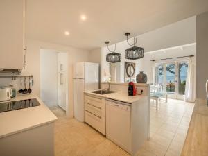 Una cocina con un refrigerador blanco y un fregadero. en Villa Ty Bihan, en Binibeca