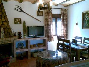 uma sala de estar com uma televisão e uma mesa de jantar em Casa Rural El Parral, Sierra Cazorla em Pozo Alcón