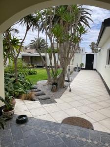a courtyard with palm trees and a walkway at The Beach Residence in Swakopmund