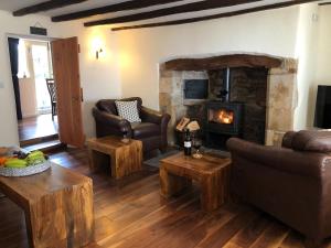a living room with a couch and a fireplace at Church View Cottage & Barn in Hatherleigh