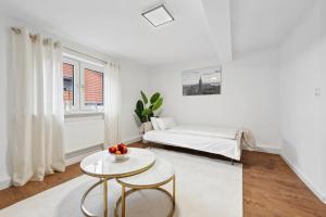 a white room with a bed and a table at STARLIVING Premium Home in Osthofen