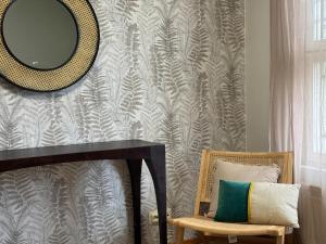 a mirror on a wall next to a table and a chair at Hotelli Unelma in Kullaa +41 photos