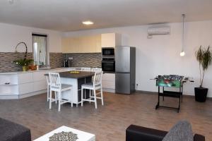 a kitchen and living room with a table and a refrigerator at Ingrid Vendégház és Wellness Pilisszentiván 2 in Pilisszentiván