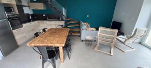 a kitchen with a wooden table and chairs at La Maison de Campagne de Léobin in Véranne