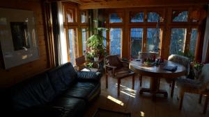 a living room with a couch and a table and windows at Valea Vinului Suite in Vişeu de Sus