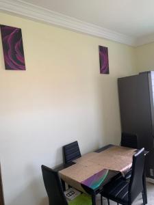 a dining room table with chairs and a table and a cabinet at 2 bedroom house Accra in Apenkwa