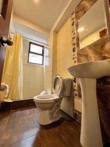un bagno con un water e un lavandino di HAYLLI QOSQO Hotel Inn a Cuzco