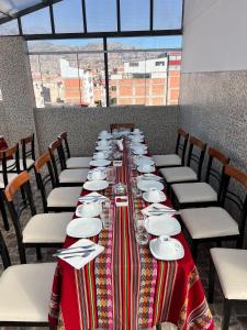 un lungo tavolo con piatti e piatti sopra di HAYLLI QOSQO Hotel Inn a Cuzco