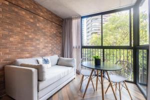 a living room with a couch and a table at Housi Faria Lima in Sao Paulo