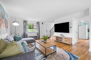 a living room with a couch and a tv at Modern and Spacious House Pittsburgh in Pittsburgh