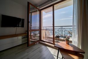 a living room with a large balcony with a television at Apartment Emma complex Carpe Diem Balchik in Balchik