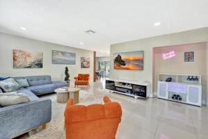 a living room with a blue couch and a tv at Villa Ft Lauderdale XL Pool, playground, BBQ, beach, Family Paradise in Fort Lauderdale