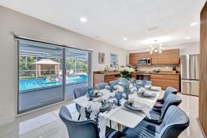 a dining room with a table and chairs and a kitchen at Villa Ft Lauderdale XL Pool, playground, BBQ, beach, Family Paradise in Fort Lauderdale