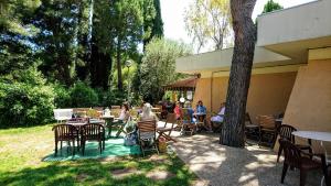 a group of people sitting at tables and chairs at Condo in a private residence with pool in Nice