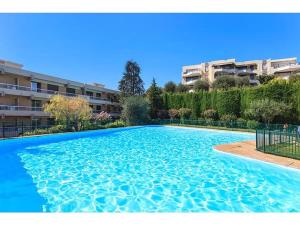 a large swimming pool in front of a building at Condo in a private residence with pool in Nice