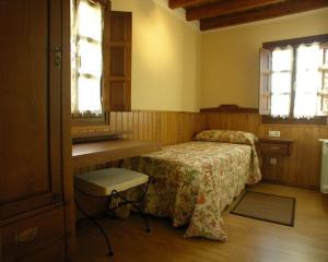 a bedroom with a bed and a sink and windows at Hotelapartamentos Torres in Selorio
