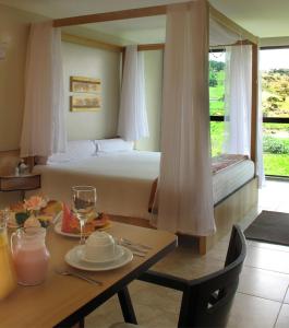 um quarto de hotel com uma cama e uma mesa com uma mesa sidx sidx em Resort Monte das Oliveiras em Joanópolis