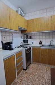 a kitchen with wooden cabinets and a stove top oven at Apartamento entero de 3 habitaciones in Santa Magdalena de Pulpis