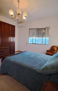 a bedroom with a blue bed and a chandelier at Apartamento entero de 3 habitaciones in Santa Magdalena de Pulpis