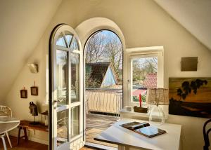 a room with an arched window and a table with a book at Fischerhütte in Fischerhude in Ottersberg
