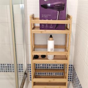 ein Holzregal im Badezimmer mit Haartrockner in der Unterkunft Apartamento La Noria pie de playa Manilva in San Luis de Sabinillas