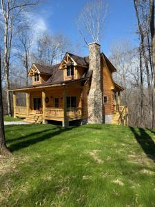 a large wooden house on top of a grass field at Turkey Creek Cabin Rentals #2 at Tims Ford lake in Tullahoma