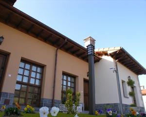 ein Haus mit einer Stange und Blumen davor in der Unterkunft Hotelapartamentos Torres in Selorio