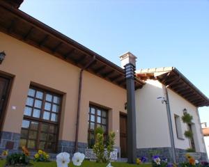 a house with a pole and flowers in front of it at Hotelapartamentos Torres in Selorio