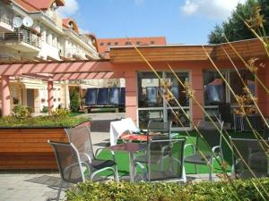 a patio with a table and chairs in front of a building at Luxory & Spa Apartman in Hajdúszoboszló
