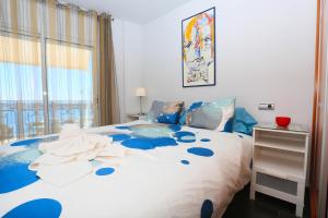 a bedroom with a blue and white bed with a window at Apartamentos La Torre in Cambrils
