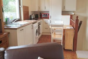 a kitchen with a sink and a stove top oven at The Snug a cosy, quirky detached cottage with sea views in Innellan