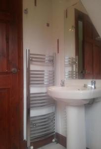 a bathroom with a sink and a mirror at The Snug a cosy, quirky detached cottage with sea views in Innellan +7 photos