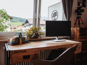 a computer monitor sitting on a desk in front of a window at Pura Vida - holiday apartment in Fischen
