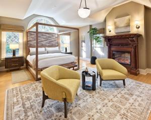 a bedroom with a bed and two chairs and a fireplace at Okaeri in Calistoga