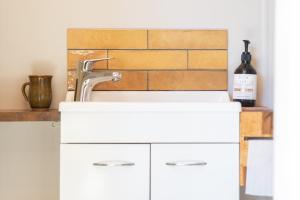 a kitchen with a sink and a bottle of wine at The Secret Studio, Outdoor Bath & Pizza Oven in New Plymouth +32 photos