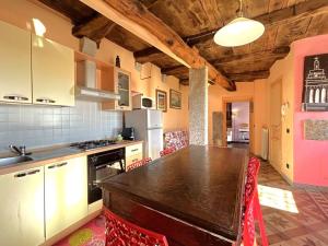 a kitchen with a wooden table in a room at LA CASA DEI SOGNI appartamento Glicine in Pisano +2 photos