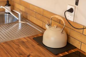 a tea kettle on a counter next to a sink at The Secret Studio, Outdoor Bath & Pizza Oven in New Plymouth