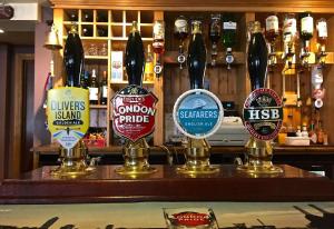a bar with different types of bottles of beer at The Elmer in Yapton