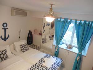 a bedroom with two beds and a window with blue curtains at Room Leon in Split