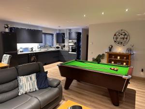 a living room with a pool table and a kitchen at Woodburn Lodges in Dumfries