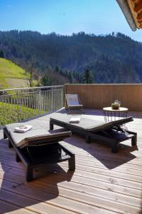 two picnic tables on a deck with a view of a mountain at Heimatglück Ferienwohnung 1 in Lautenbach