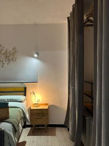 a bedroom with a bed and a night stand with a lamp at Gassa d'Amante in Montaretto