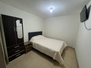 a small bedroom with a bed and a television at Centro de Tacna in Tacna