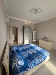 a bedroom with a large bed with blue sheets at A casa dei Nonni in Tramonti