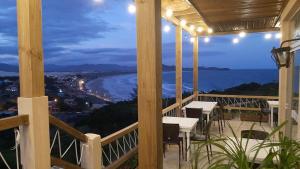 a balcony with tables and a view of the ocean at Pousada PARAÍSO 26 in Imbituba