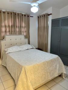 a bedroom with a bed with a white comforter at Villas Carela in Cabarete