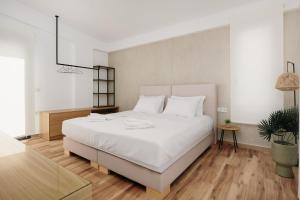 a bedroom with a large white bed and a table at Kyan Executive Suites in Iraklitsa