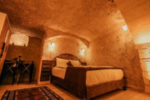 a bedroom with a bed in a stone room at akile ablanın evi in Ürgüp