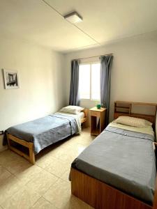 a bedroom with two beds and a window at Tu espacio ideal, Amplia y Luminosa en Rio gallegos in Río Gallegos